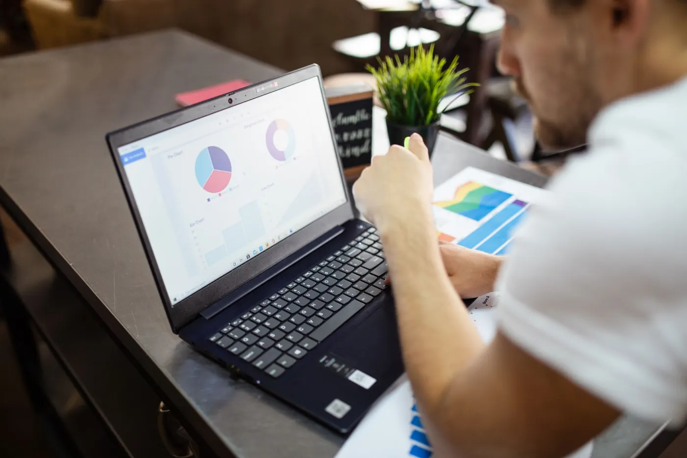 A laptop open on a page of charts in a café