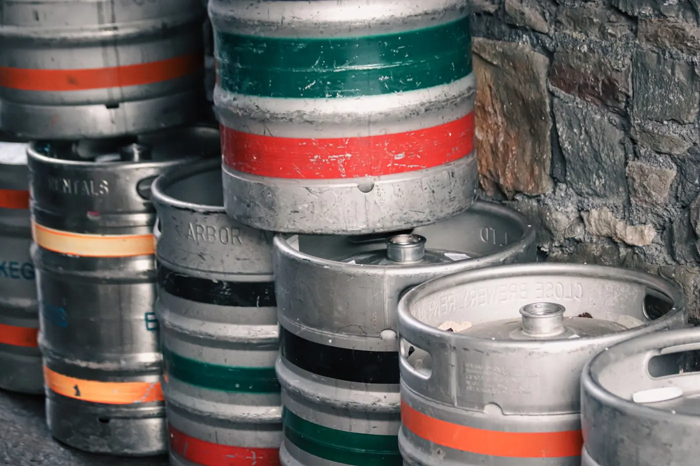 Beer kegs stacked against a stone wall, waiting to be checked in