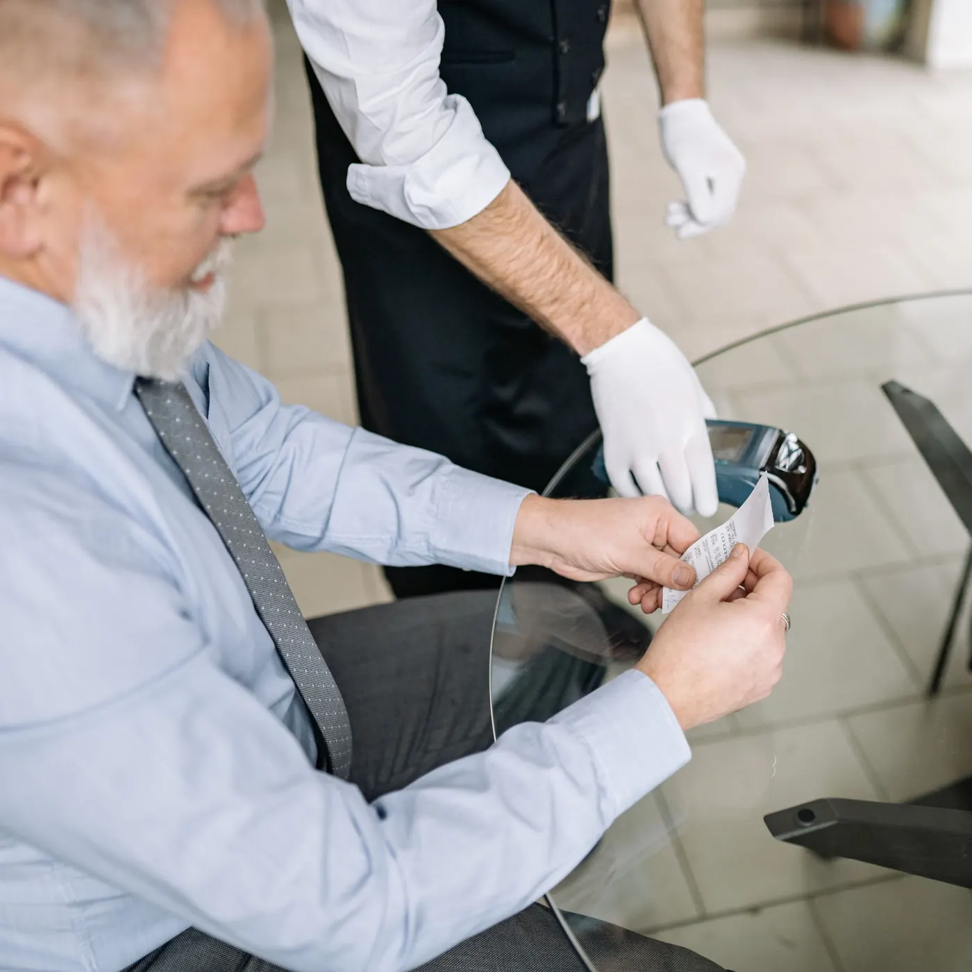 A guest paying at the table with a card terminal