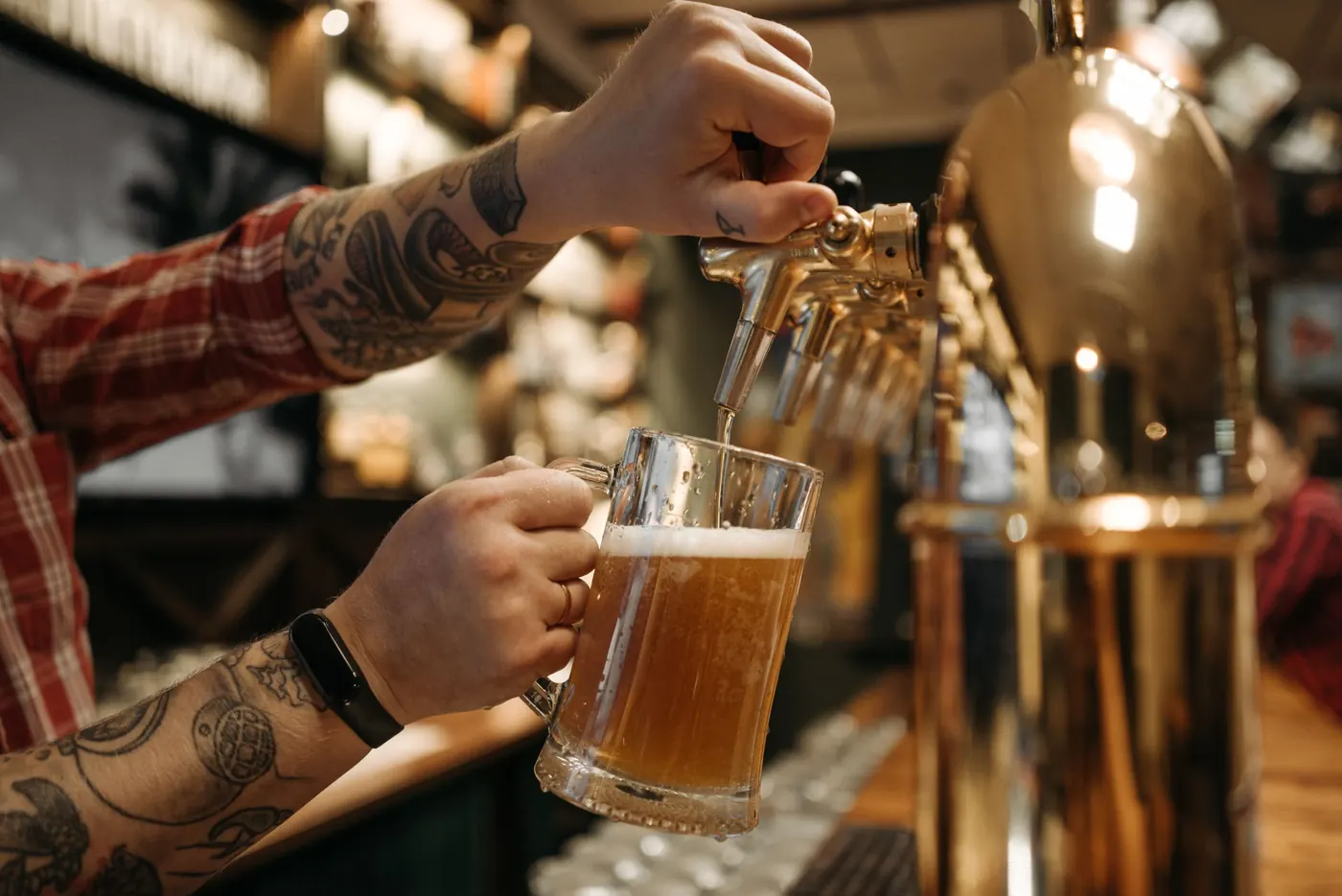 A bartender pulling a pint at the tap